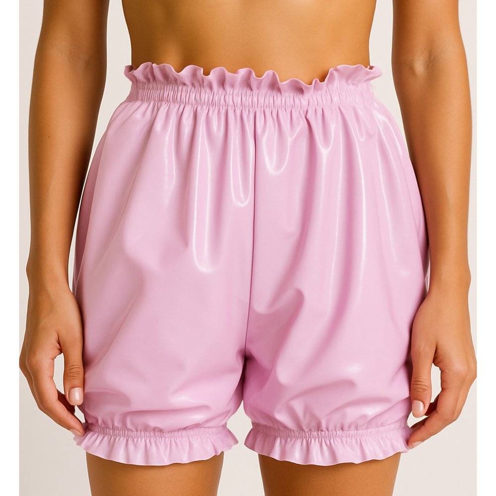 Model wearing shiny pink latex bloomers with ruffled waist and leg trims – vintage-style latex shorts handmade in London
