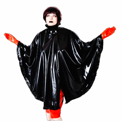Model wearing Latex Cape ROBIN in black vegan latex with red gloves and skirt, featuring frilled edges, stand-up collar, and front snap closure